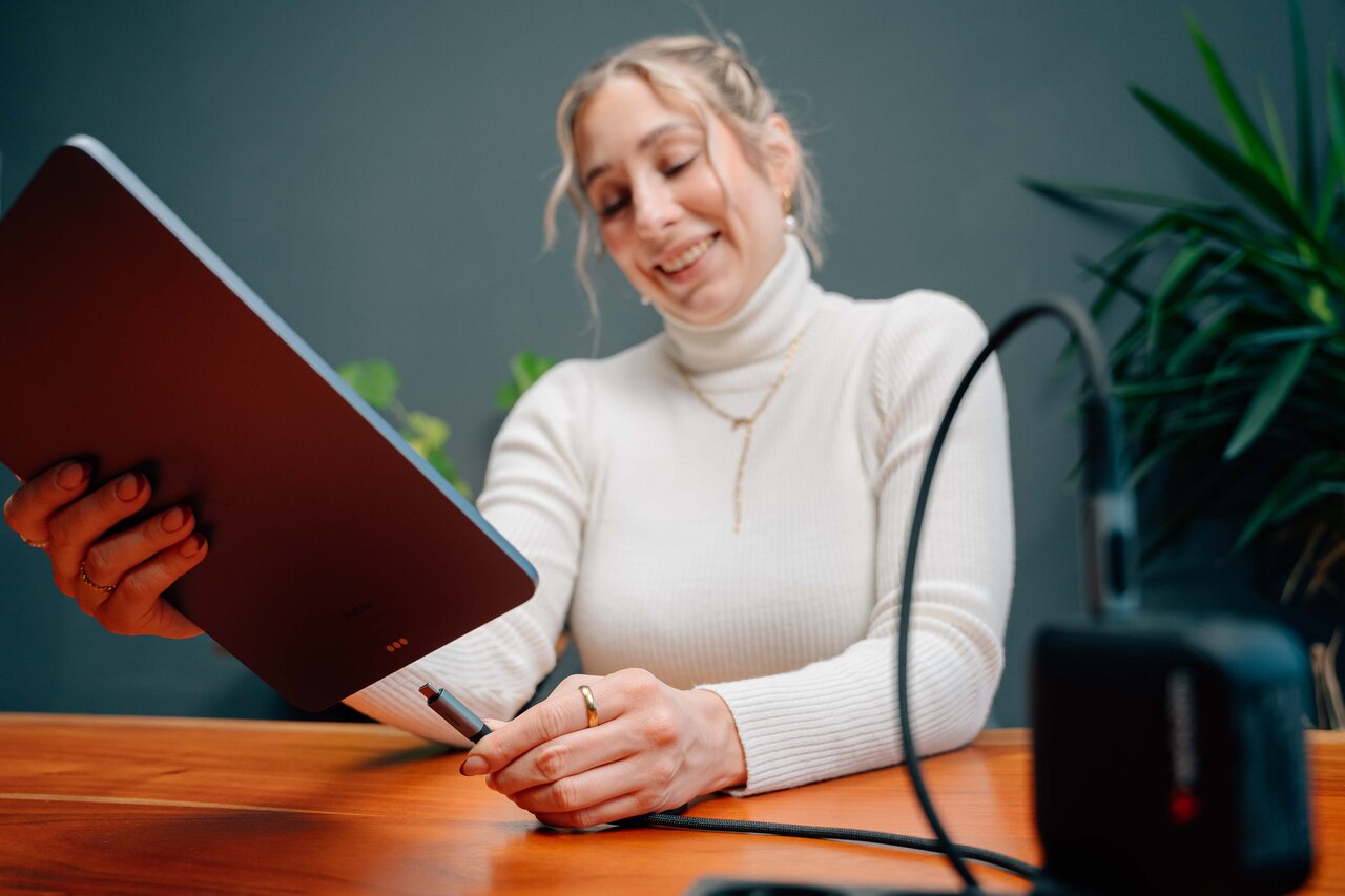 woman plugging a cable into an ipad, attached to a portable charger