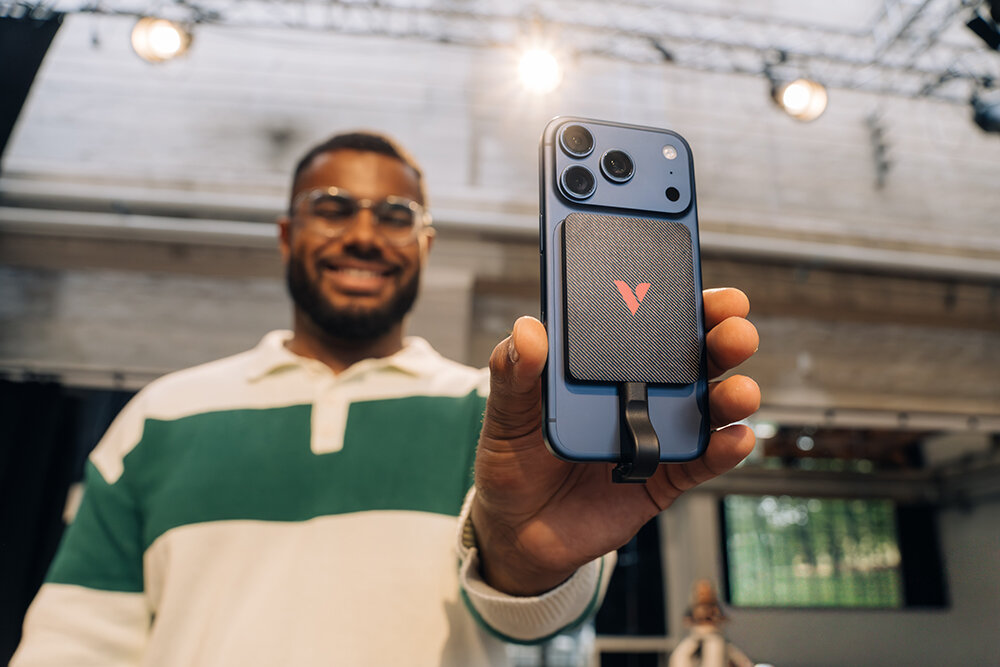 Man holding an iPhone with a Snapback UltraSlim SSD attached to it
