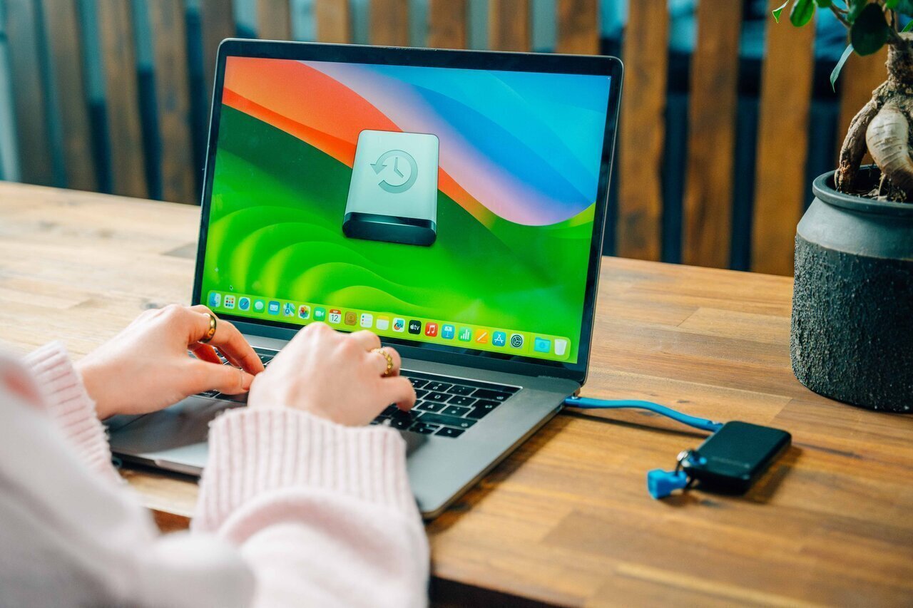 laptop on a desk showing backup software with a pocket ssd attached