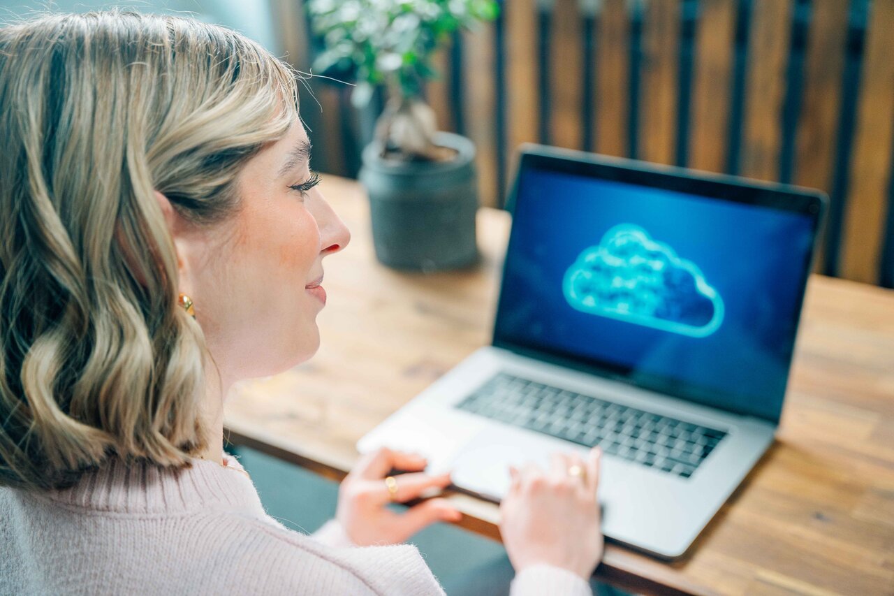Woman at a desk with laptop doing a backup to the cloud