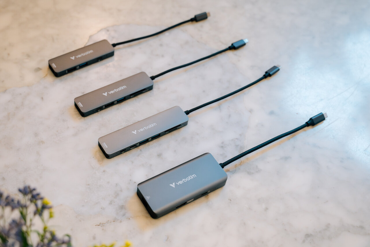Four silver Verbatim USB-C Hubs on a marble countertop.