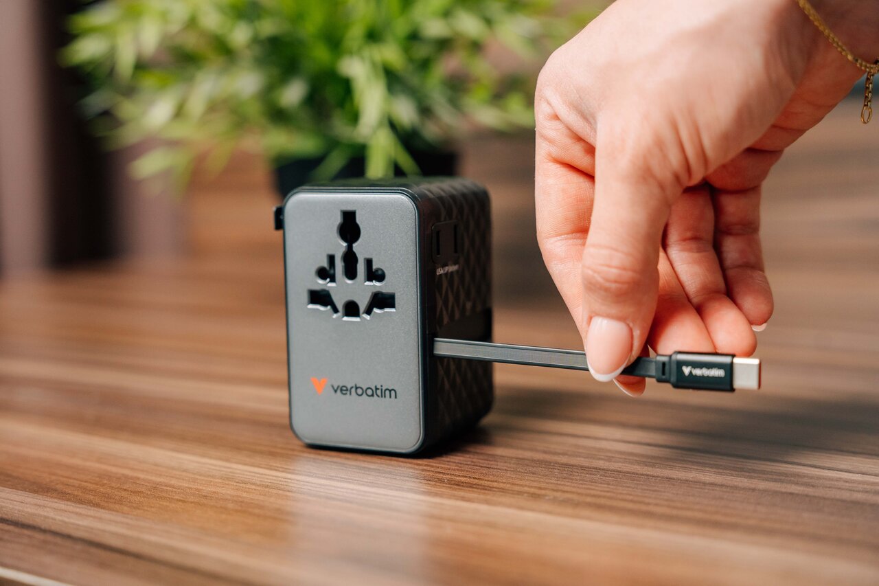 Hand pulling a USB-C cable out of a Verbatim travel plug.